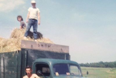 Collecting hay Summer 1962 – Robert Gagnon, standing on ground, in front of 1946 Ford Truck, with Warren Shaw Jr. and his sister Ruth standing on top.